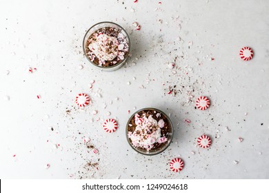 Peppermint Mocha Mousse With Whipped Cream And Crumbled / Crushed Peppermint Candies, Top View. Chocolate, Coffee And Mint Dessert & Sweet Treat. 2 Whiskey Glasses / Tumblers.