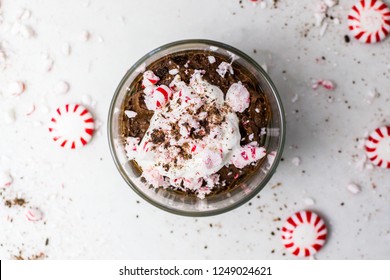 Peppermint Mocha Mousse With Whipped Cream And Crumbled / Crushed Peppermint Candies, Top View. Chocolate, Coffee And Mint Dessert & Sweet Treat. Close Up. Whiskey Glass / Tumbler.