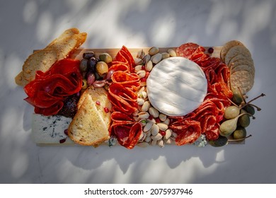 Pepperoni, Pistachio Nuts, Olives, Bread, Crackers, And Cheese On Wood Board And Granite. Aesthetic Food, Spread, Grazing Board, And Charcuterie.