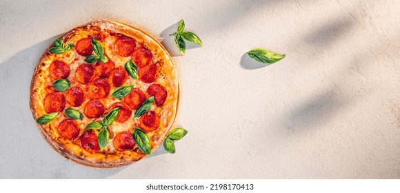 Pepperoni Pizza With Basil On Stone Texture In Sunlight