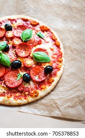 Pepperoni Pizza With Fresh Ingredients On Brown Baking Paper Background, Top View. Banner Or Wallpaper 
