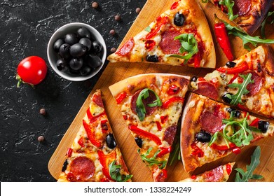 Pepperoni Pizza with Mozzarella cheese, salami, Tomatoes, olive, pepper, Spices and Fresh arugula. Italian pizza on dark background