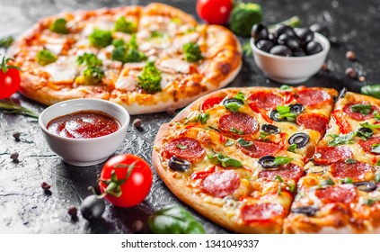 Pepperoni Pizza mit Mozzarella Käse, Salami, Tomaten, Oliven, Pfeffer, Gewürze und frische Basilika und Pizza mit Käse, Lachs Fisch, Broccoli, Tomatensauce. zwei italienische Pizza auf dunklem Hintergrund