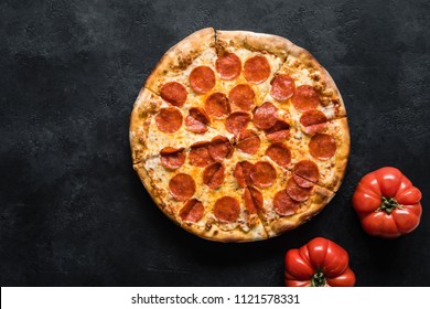 Pepperoni pizza on black concrete background. American pepperoni pizza, top view - Powered by Shutterstock