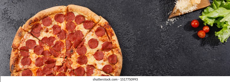 Pepperoni Pizza On A Black Texture Background. Still Life. Top View. Banner.