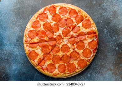 Pepperoni Pizza On The Board On Dark Blue Stone Table Top View