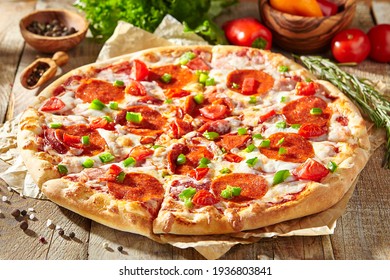 Pepperoni-Pizza mit Pizzasauce, Mozzarella-Käse und Pepperoni. Pizza auf Holzbrett auf Holztisch mit Zutaten