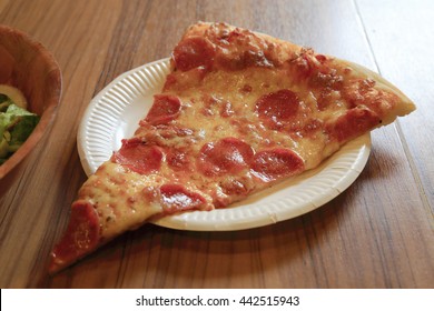 Pepperoni Pizza Slice On Paper Plate Over Wooden Table