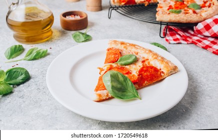 Pepperoni Pizza Slice On Plate On Light Gray Background. Traditional Italian Fastfood. With Red White Checkered Towel. Selective Focus