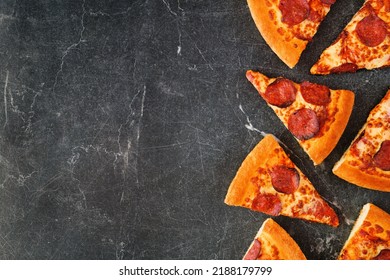 Pepperoni Pizza Slice Side Border. Above View Over A Dark Slate Background. Copy Space.