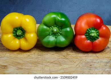 Peppers in three colours on a kitchen breadboard