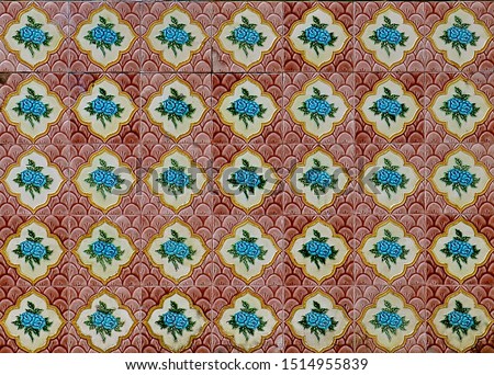 Peranakan tile mosaic as typically found on traditional Chinese shop houses, with turquoise blue flowers on a scalloped red and maroon background. 