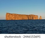 Perce Rock illuminated at sunset at high tide and the Gulf of St. Lawrence, Perce, Gaspesie, Quebec, Canada, North America