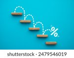 Percent sign moving down from top stair on blue background. Central banking system of the United States FED (Federal Reserve System) cut interest rate, world finance and economy concept.