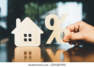 Percentage and house sign symbol icon wooden on wood table. Concepts of home interest, real estate, investing in inflation.	 - Shutterstock ID 2295687905