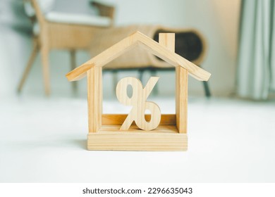 Percentage and house sign symbol icon wooden on wood table. Concepts of home interest, real estate, investing in inflation. - Shutterstock ID 2296635043