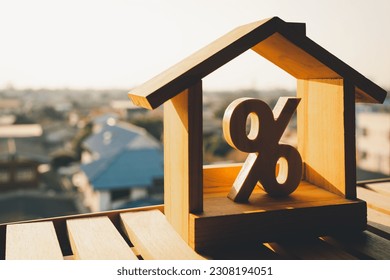 Percentage and house sign symbol icon wooden on wood table. Concepts of home interest, real estate, investing in inflation.	 - Shutterstock ID 2308194051