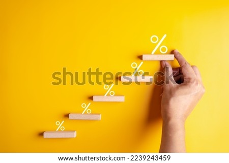 Percentage sign of hand arranging wood blocks stacking as step stair with percent symbol,  interest rate and business profit growth concept.