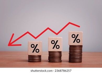 Percentage sign on wooden cubes with Stack of coin bar chart and red graph trending downwards on white background. Economy recession crisis, inflation, stagflation, business and financial loss concept