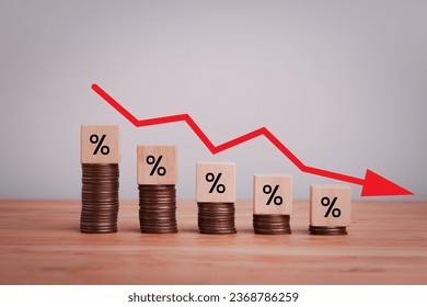 Percentage sign on wooden cubes with Stack of coin bar chart and red graph trending downwards on white background. Economy recession crisis, inflation, stagflation, business and financial loss concept
