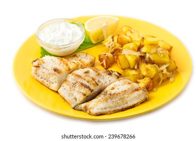 the perch fish grill with potatoes and lemon and sauce on the yellow plate 