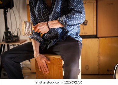 Percussionist Playing A Cabasa And A Flamenco Drum Box At The Same Time.