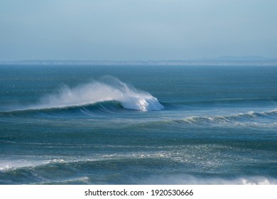 Perfect big wave breaking on a offshore wind bright sunny day on a sandy beach break