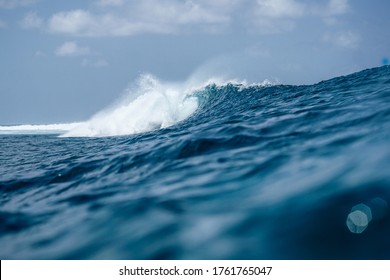 Perfect blue aquamarine wave, empty line up, perfect for surfing, clean water, Indian Ocean close to Maldivian island Thulusdhoo, from water