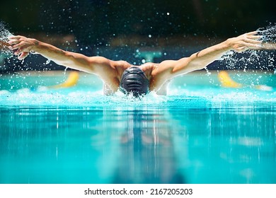 Perfect butterfly stroke. Shot of a male swimmer doing the butterfly stroke toward the camera. - Powered by Shutterstock