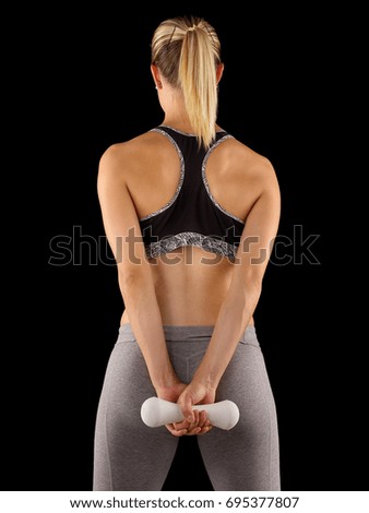 Perfect buttocks. Rear view of sporty woman with perfect buttocks holding dumbbells while standing 