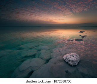Perfect clouds reflection in the Dead Sea during fantastic dawn. Spiritual and mystic atmosphere. Above and underwater salt formations. Lowest elevation, Ein Gedi, Ein Bokek, south district, Israel.