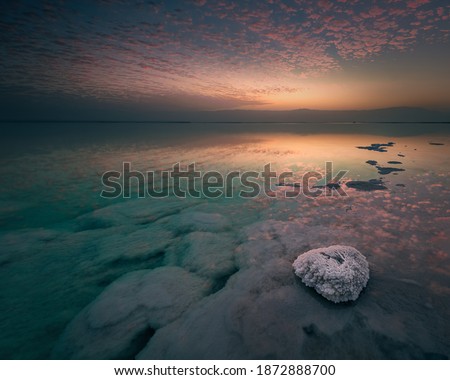 Perfect clouds reflection in the Dead Sea during fantastic dawn. Spiritual and mystic atmosphere. Above and underwater salt formations. Lowest elevation, Ein Gedi, Ein Bokek, south district, Israel.