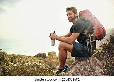The perfect day to be out in nature.... Shot of a young man taking a water break while out hiking. - Shutterstock ID 2134321691