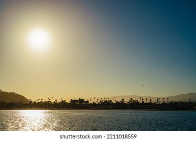 Perfect Golden Blue Santa Barbara Beach With Palm Trees Silhouettes Against Hills And Ocean. Holiday Bliss In Tropical Locations Nature Travel Landscape Background