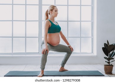 Perfect Health During Pregnancy. Full Length Portrait Of Pretty Young Future Mother Wearing Workout Clothes And Doing Physical Exercises At Home