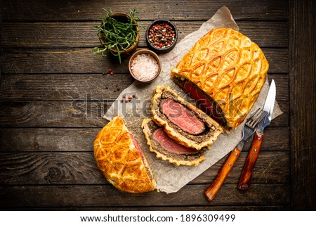 Perfect homemade juicy Beef Wellington, tenderloin dish on rustic wooden table, top view