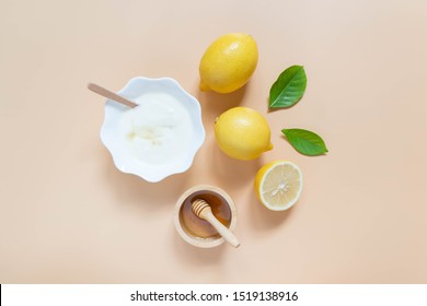 Perfect Homemade Natural Face Mask Ingredients For Bright And Healthy Skin. Top View Of Yogurt, Lemon And Honey On Orange Background. Beauty Herbal Skincare Product Concept. Flat Lay.