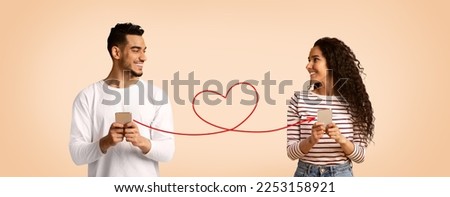 Perfect Match. Smiling Arab Man And Woman Holding Smartphones Connected With Drawn Red Heart Shape String, Romantic Middle Eastern Couple Using Modern Dating App, Creative Collage, Panorama