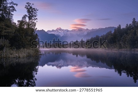 Perfect mirror reflection of Mount Cook and Mount Tasman in the dark waters of Lake Matheson, New Zealand.