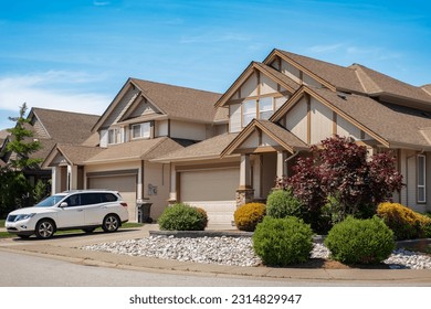 A perfect neighborhood. Houses in suburb at summer in the north America. Real Estate Exterior Front Houses. Big custom houses with nicely landscaped front yard and driveway to garage in the suburbs