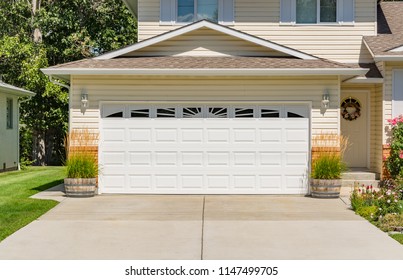 A perfect neighbourhood. Family house with wide garage door and concrete driveway in front
