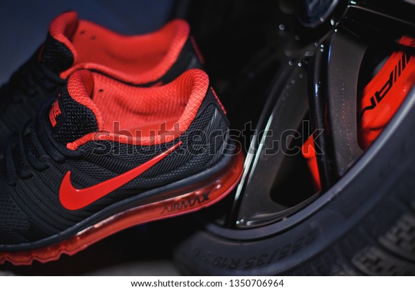 Perfect Nike Air Max 2017 sport\
shoes shot near the Mercedez Benz car on dark background. Sport and\
casual footwear concept. Krasnoyarsk, Russia - January 10,\
2018
