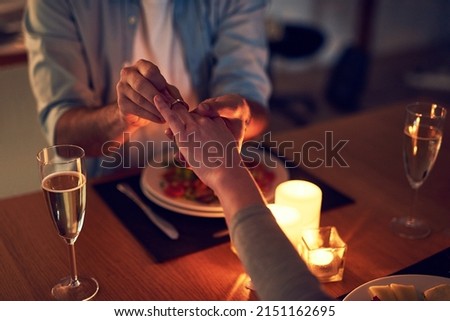 The perfect occasion. Cropped shot of an unrecognizable man proposing to his wife over a candle lit dinner at night. Foto stock © 