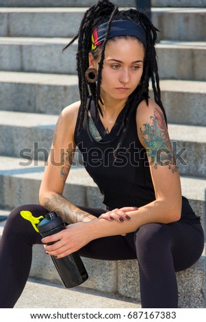 Perfect outdoor female fitness training. Portrait of young and beautiful girl with tattoo having sport outdoor workout. Active gym workout. Healthy alternative sportsmen concept