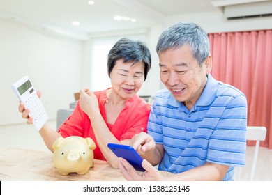 Perfect Retire plan concept - eldely couple hold piggy bank and calculator happily at home - Powered by Shutterstock