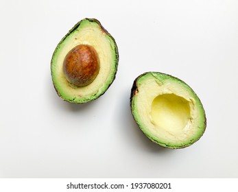 Perfect ripe avocado in halves. Top view on white background. Fresh avocados. 