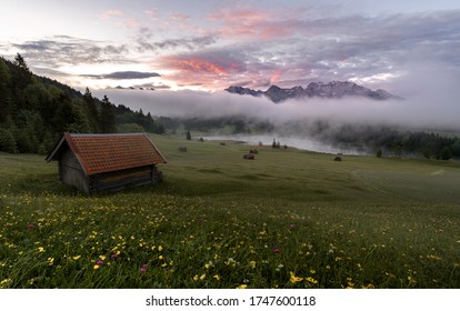 Perfect scenic sunrise in the Mountains - huts, lake, fog, colorful sky - Powered by Shutterstock