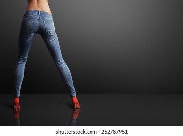 Perfect Shaped Woman Wearing Skinny Jeans In A Dark Room