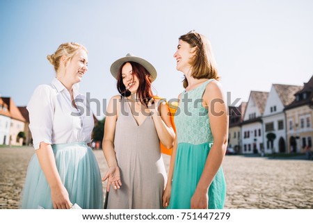 Perfect shopping. Three young pretty stylish girls are holding the shopping bags and looking forward in a good mood