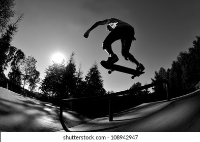 perfect silhouette of a skateboarder doing a flip trick at the skate park. - Powered by Shutterstock